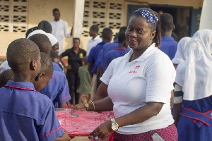 Maame Dufie Cudjoe, CSR Manager hands over a bag to one of the students