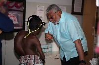 Former President Jerry John Rawlings interacting with a deformed patient