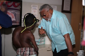 Former President Jerry John Rawlings interacting with a deformed patient