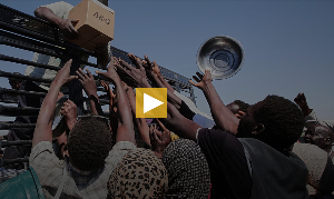 Sudanese families displaced from El-Fasher reach out as aid workers distribute food supplies