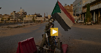 An empty checkpoint where a mannequin dressed as a soldier stands in downtown Khartoum
