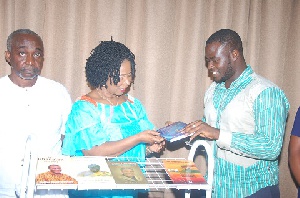 Mrs Comfort Aniagyei (M) presenting the books to Mr. Abdul Razak Iddrisu