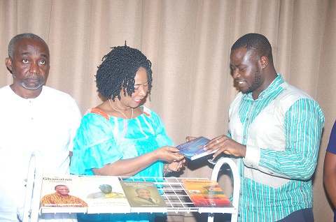 Mrs Comfort Aniagyei (M) presenting the books to Mr. Abdul Razak Iddrisu