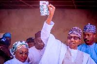 President Buhari displays his ballot after voting in his hometown of Daura