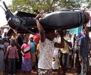 The suspected thief carrying the stolen motorbike