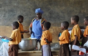 School children line up for school feeding meals