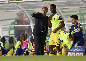 Jose Mourinho (L) giving instructions to Mikel Obi (R) during a game