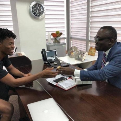 Kwesi Arthur receiving the gift from Bola Ray