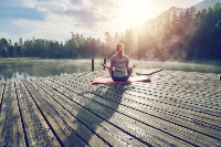 A woman meditating by the river