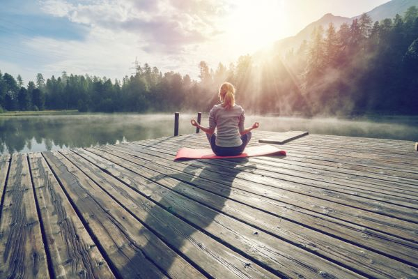 A woman meditating by the river