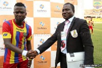 Malik Akowuah receiving his reward from a representative of the title sponsors