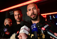 Andrew Tate and his brother Tristan speak to the media as they arrive in Bucharest, Romania