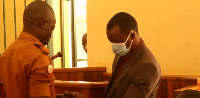 A prison warder handcuffs Swaibu Mirundi, 44, as he appeared at Mpigi Magistrate's Court