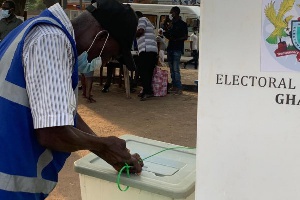 File: A presiding officer is seen securing the ballot after voting