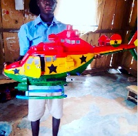 Here is a photo of a young Ghanaian boy who has manufactured an helicopter from plastic waste