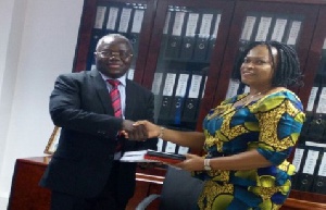 Siengui Apollinaire (left) receiving the documents from Ifeyinwa Ikeonu