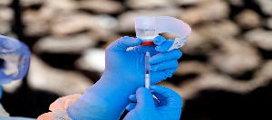 A health worker fills a syringe with the Ebola vaccine before injecting it into a patient