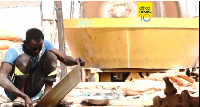 A front-loader loads dirt and crushed rock into a processing machine used to separate gold-bearing