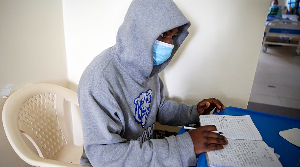 Patient studies while receiving treatment in a COVID-19 ward at Kenyatta Hospital