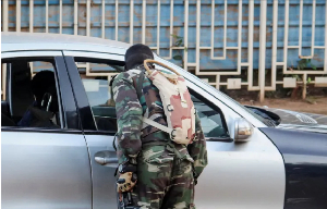A soldier checks a vehicle at a checkpoint following a mutineers' attack on airport and presidency A soldier checks a vehicle at a checkpoint following a mutineers' attack on airport and presidency