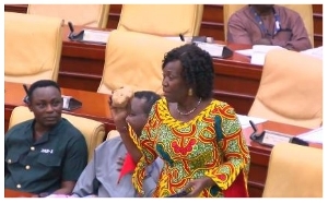 Della Adjoa Sowah displaying a ball of kenkey on the floor of parliament