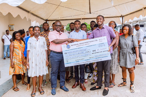 Francis Asenso-Boakye presenting one of the scholarships to a beneficiary
