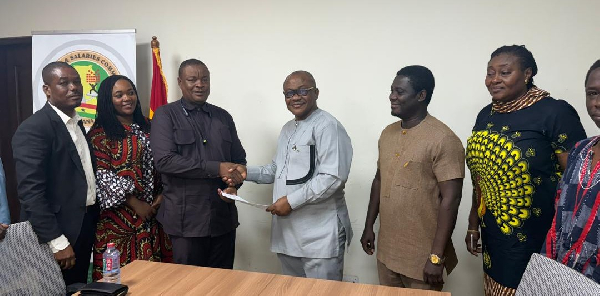 Dr Graham (M) with the team during the agreement signing