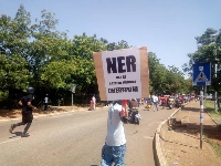 A youth holding a placard that reads 'North-East Region can be created without Chereponi' on it