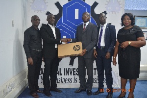 Executives of NIB presenting the laptop to Mr Kwabena Adu Koranteng