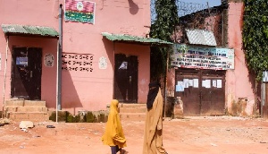 Young girls walk past a boarding school in Kaduna where hundreds of students were rescued in 2019