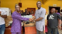 The MP (right) hands over the computers to the headmaster of the school