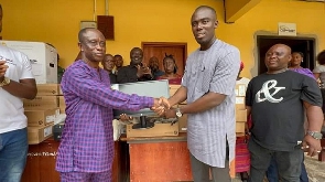 The MP (right) hands over the computers to the headmaster of the school