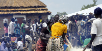 Women and men prepare a meal for South Sudan refugees in Pagirinya Refugee Settlement in Adjumani