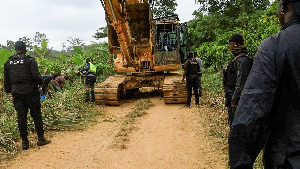 Police trying to move the excavator during the operation in the forest reserve