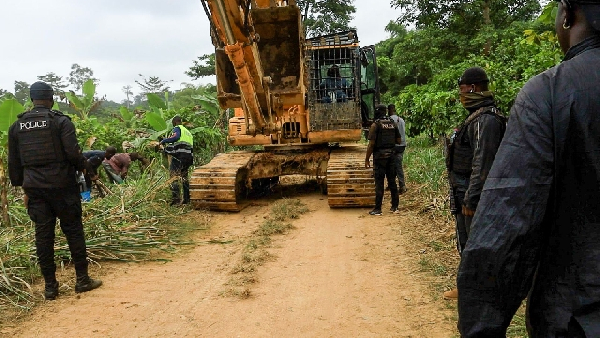 Police trying to move the excavator during the operation in the forest reserve