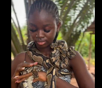 Taiwo Okikiola plays with the snakes