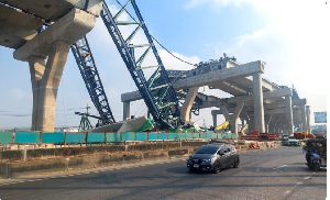 Cars drive next to a collapsed crane that crushed two vehicles during construction Cars drive next to a collapsed crane that crushed two vehicles during construction