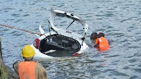 Rescuers retrieve a car from the ocean after it plunged into the Makupa Causeway