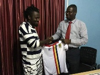 Malik Akowuah with an official of Hearts of Oak during the signing of the contract