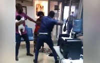 A police officer seen beating a lady with a child
