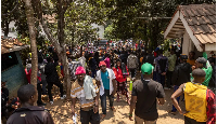 Burundian nationals gather outside their embassy to apply for border passes