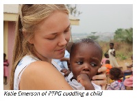 Katie Emerson of  PTPG cuddling a child