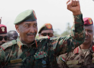 Sudan's army chief Abdel Fattah al-Burhan gestures to soldiers inside the presidential palace