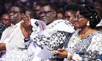 Pastor Mensah Otabil (m) giving a round of applause at a programme