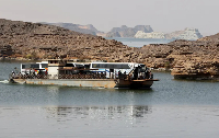 Sudanese and people from other nationalities cross the Nile river in a ferry, after being evacuated