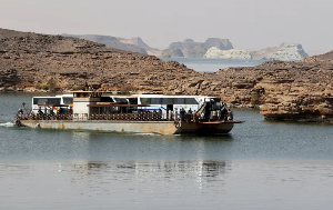 Sudanese and people from other nationalities cross the Nile river in a ferry, after being evacuated