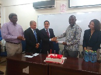 The Lebanese ambassador to Ghana (L) presenting the cheque to professor Kwansah-Aidoo