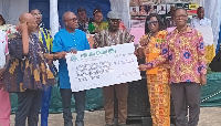 Chairman of ADA, Mr. MacDonald Bubuama, receiving a dummy cheque from Mr. Samuel Aboni