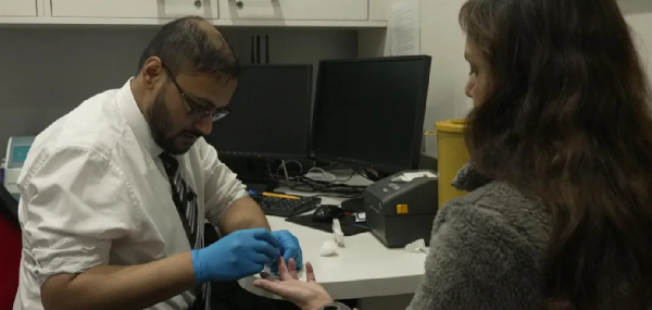 A finger-prick blood test is used to assess cholesterol levels