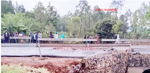 Locals gather at Nalugugu Bridge which was washed away by floods in Sironko District